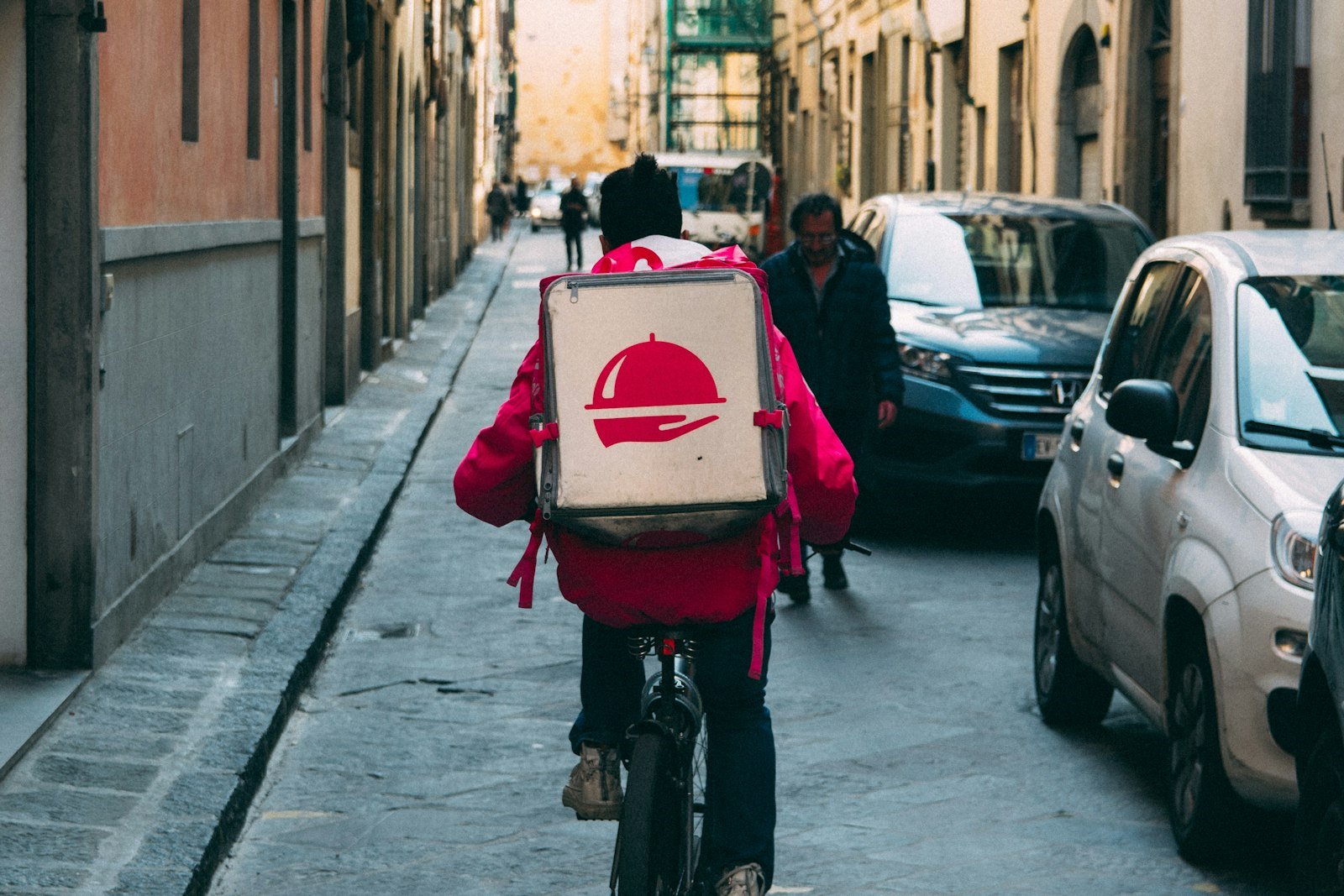A Ember & Vine courier cycling an order through the city