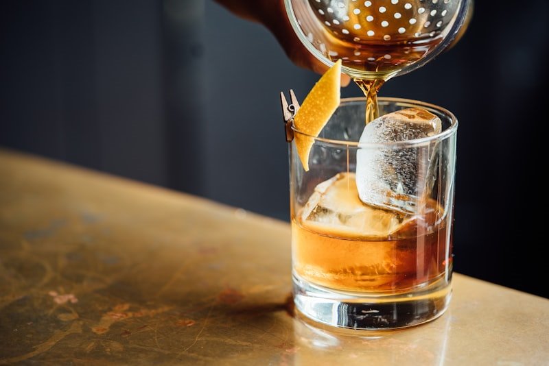 A cocktail being poured at the bar